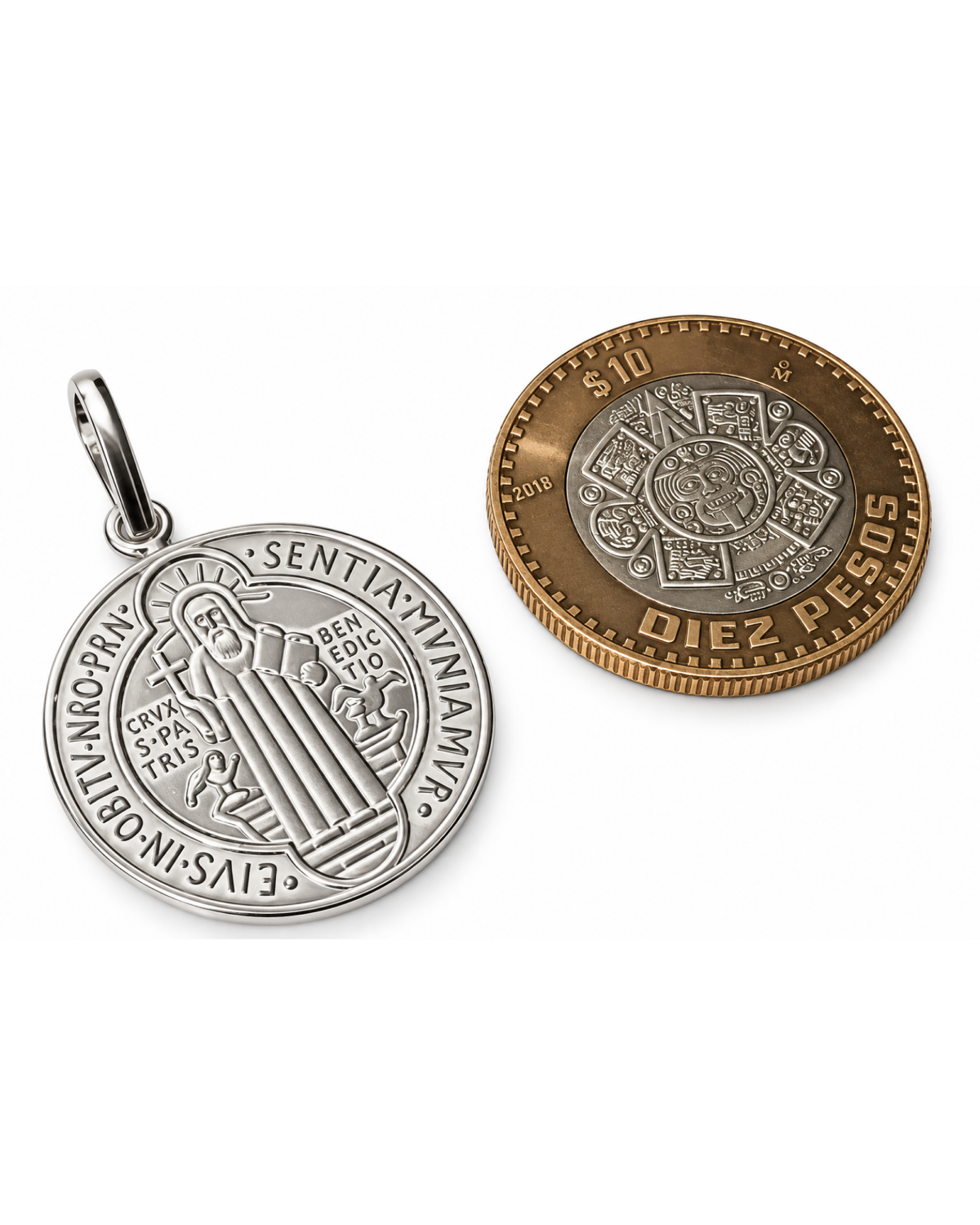 Medalla de San Benito de plata .925 junto a una moneda para referencia de escala.